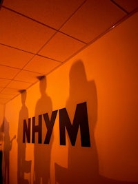 a group of people standing in front of the nhym sign